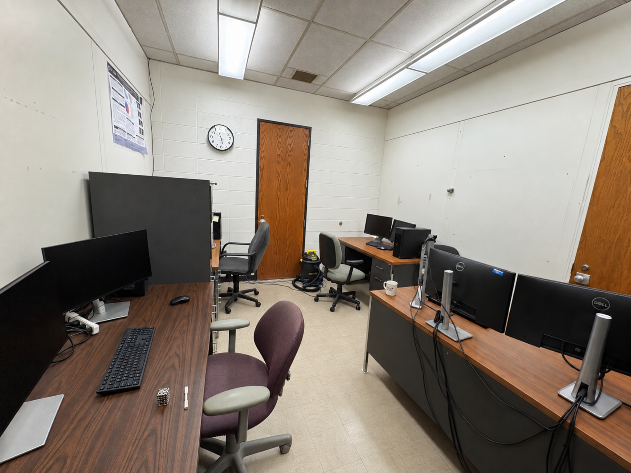 The Lab811 graduate research office in D0015, with desks, computing workstations, and a whiteboard.