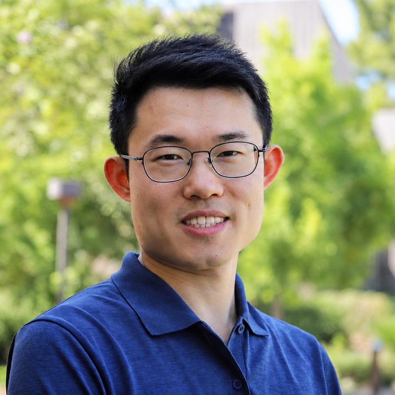 Portrait of Yupeng Zhang outdoors on campus.